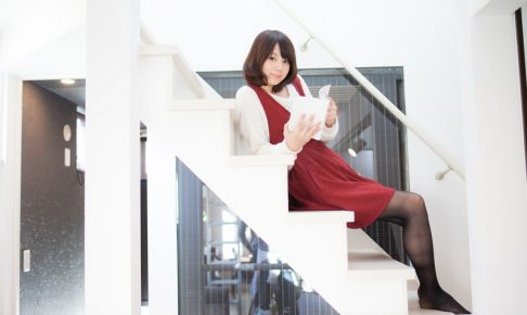 階段で本を読んでいる女性