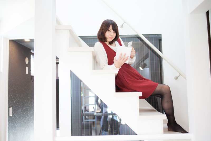 階段で本を読んでいる女性