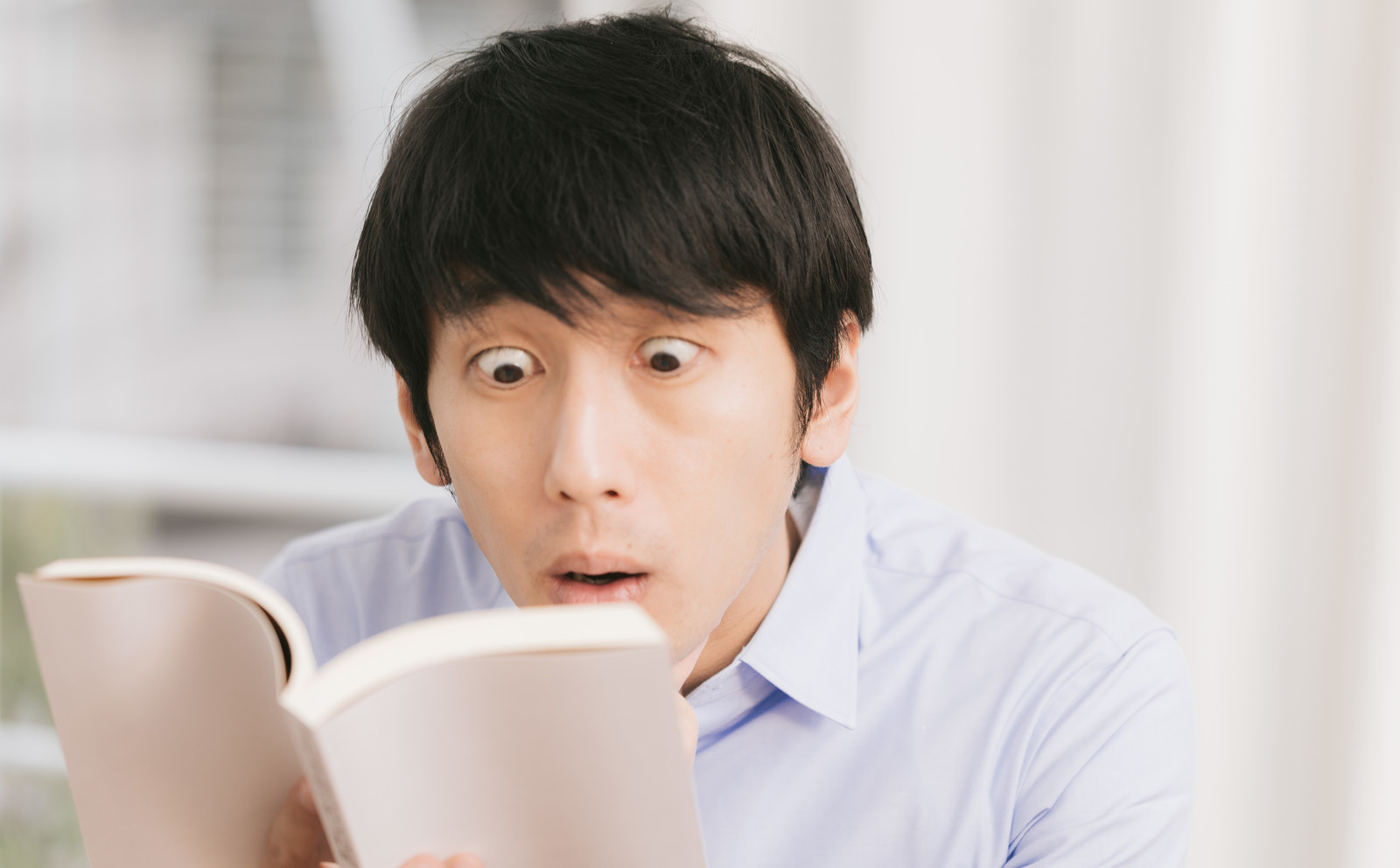 衝撃展開に驚く読書中の男性