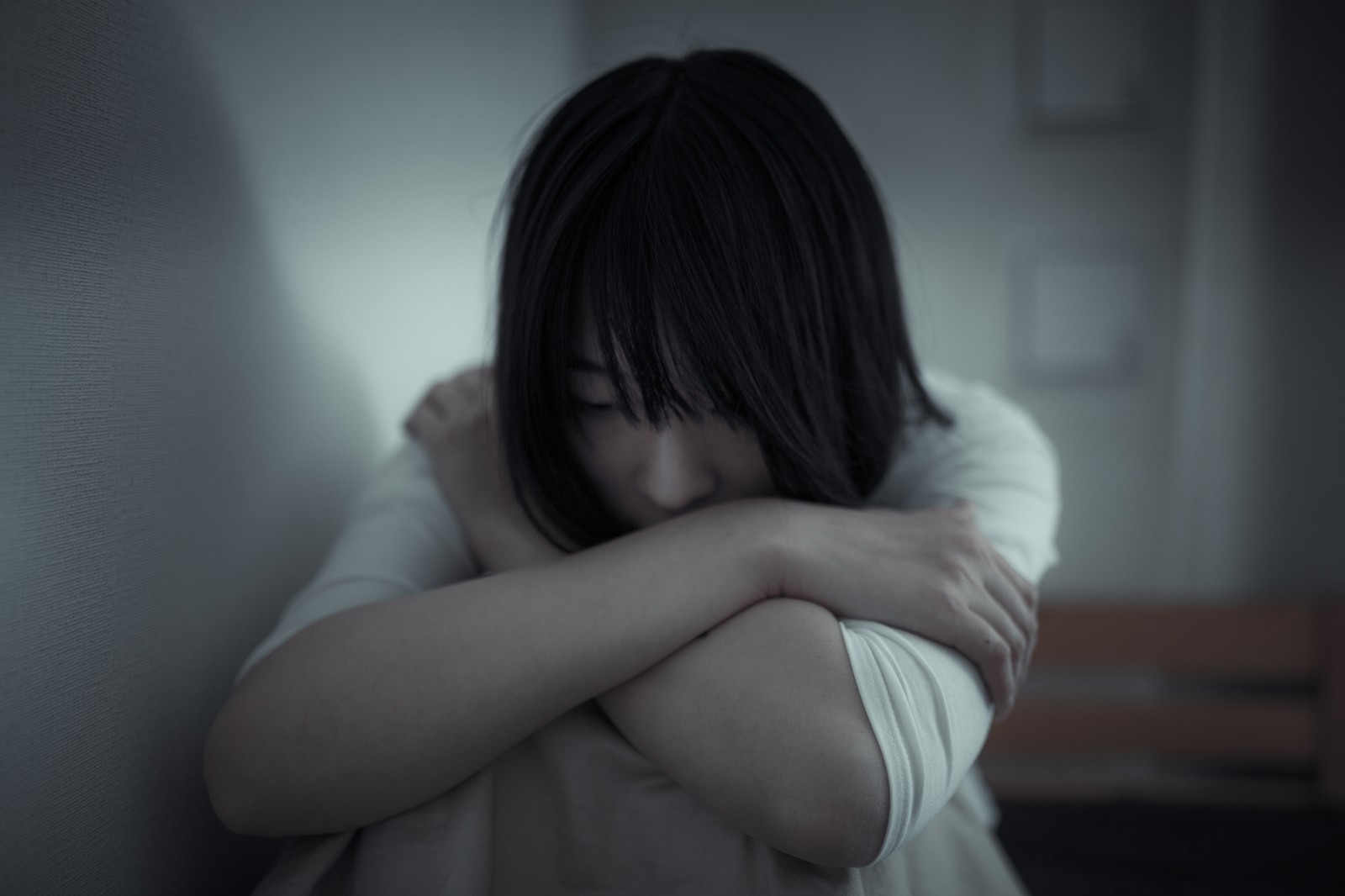 膝を抱える女性